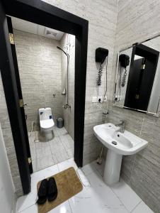 a bathroom with a sink and a toilet and a mirror at استديو غرفة نوم بدخول ذكي in Jazan