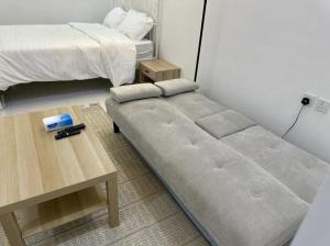 a bed sitting in a room next to a table at استديو غرفة نوم بدخول ذكي in Jazan