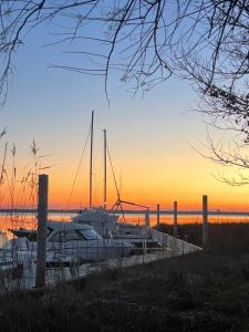 a group of boats docked at a marina at sunset at Duplex proche du port in Audenge