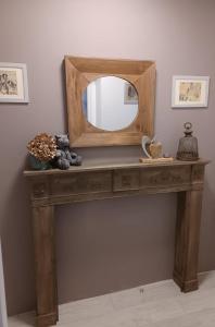 a wooden console table with a mirror on it at le Roy de coeur in Riquewihr