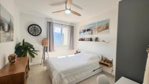 a bedroom with a bed and a clock on the wall at Appartement Le Millie 3 chambres Hyper centre in Calvi