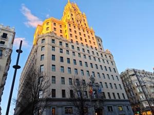 a tall building with a clock on the top of it at Hostal Aliste in Madrid