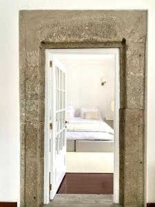 a bedroom with a bed through a doorway at CASA de FORO - Apartamentos Turísticos in Angra do Heroísmo