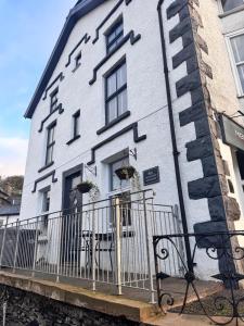 a white building with a fence in front of it at High Street Apartment in Windermere