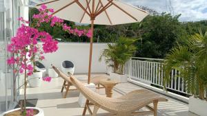 eine Terrasse mit Stühlen und einem Sonnenschirm auf dem Balkon in der Unterkunft Villa Nyra Padang Padang in Bingin Beach