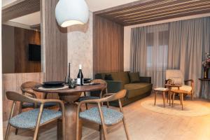 un soggiorno con tavolo, sedie e divano di Apart-hotel Pahulja a Jahorina
