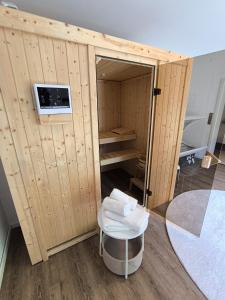a wooden sauna with a stool and a table at Waldnest Eifel in Kerschenbach +28 photos