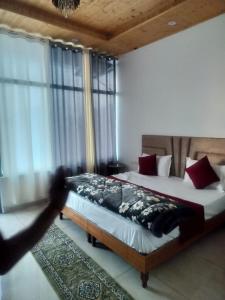 een slaapkamer met een bed en een persoon die een foto neemt bij Hotel Kasauli Peak View - Family and Group Stay Apartments in Parwanoo