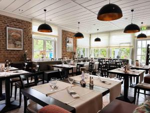 a restaurant with tables and chairs and windows at Charly's Gare in Senningerberg +13 photos