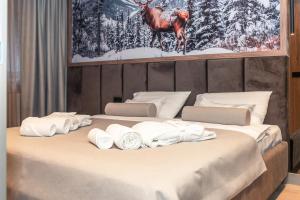 un grande letto con asciugamani bianchi di Apart-hotel Pahulja a Jahorina