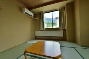 a room with a wooden table and a window at Hotel Chalet Ryuo in Yamanouchi