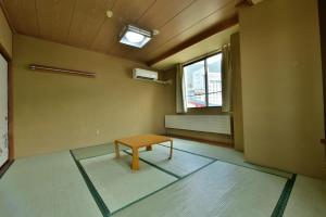 a room with a table in a room with a window at Hotel Chalet Ryuo in Yamanouchi