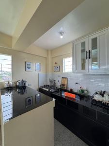 バレルにあるThe house auroraのキッチン(黒いカウンタートップ、白いキャビネット付)