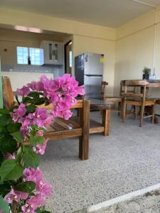 バレルにあるThe house auroraの紫色の花と冷蔵庫のあるリビングルーム