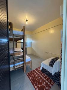 バレルにあるThe house auroraの二段ベッド2台と赤いラグが備わる客室です。