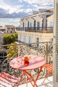 a table and chairs on a balcony with a building at Hôtel Amista Marseille in Marseille
