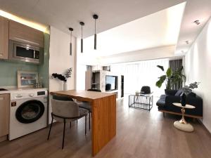 北京市にあるBeijing Sanlitun Shimao International Serviced Apartmentsのキッチンとテーブルとソファのあるリビングルーム