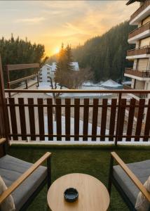 a table and chairs on a balcony with a view at Studio au Cœur des Sommets in Crans-Montana