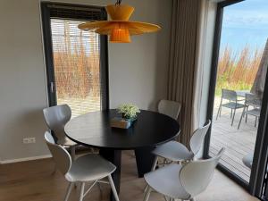 ein Esszimmer mit einem schwarzen Tisch und Stühlen in der Unterkunft Enkhuizer Strand BeachHouse Sinne Nr 514 in Enkhuizen + 14 Fotos