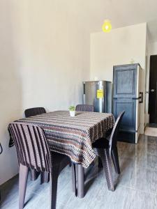 een eettafel met stoelen en een koelkast bij Cozy Studio with Queen Bed in Malaybalay City 