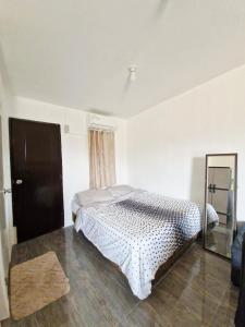 een slaapkamer met een bed en een spiegel bij Cozy Studio with Queen Bed in Malaybalay City 