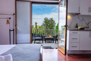 a kitchen with a large glass door leading to a balcony at Solar do Pico Studio in Ponta Delgada
