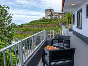 a balcony with two chairs and a table and a castle at Solar do Pico Studio in Ponta Delgada