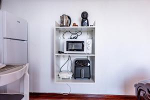 a kitchen with a microwave on a shelf at Solar do Pico Studio in Ponta Delgada