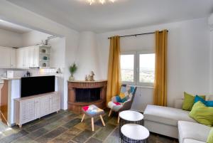 a living room with a couch and a fireplace at Theasis Serenity Residence, Panoramic Sea View Villa with Private Pool in Sklavedhiákos