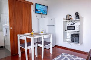 a small kitchen with a table and chairs and a microwave at Solar do Pico Studio in Ponta Delgada +13 photos