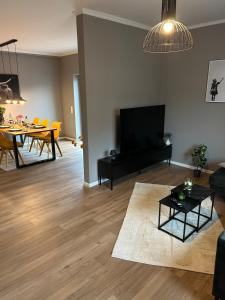 a living room with a television and a dining room at Ferienwohnung Hodenhagen in Hodenhagen