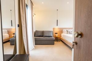 a bedroom with a bed and a couch and a chair at Naiades Guest House in Sálakos