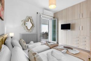 a living room with a large white couch and a mirror at Panos Apartment Naousa in Naousa