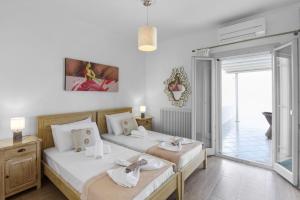 a bedroom with two beds and a sliding glass door at Panos Apartment Naousa in Naousa