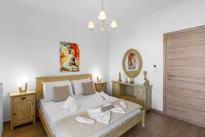 a bedroom with a bed with white sheets and a mirror at Panos Apartment Naousa in Naousa