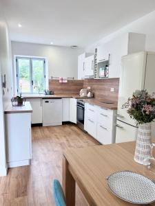 Una cocina con electrodomésticos blancos y suelo de madera. en Maison avec grand jardin en centre ville, en Le Blanc