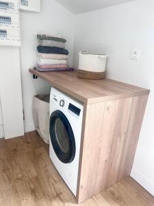 Una lavadora y secadora debajo de un estante en un lavadero. en Maison avec grand jardin en centre ville, en Le Blanc