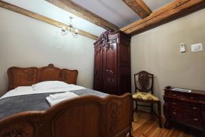 a bedroom with a wooden bed and a dresser at Spichlerz Ostoya in Jasionka