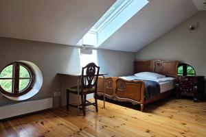 a bedroom with a bed and a desk and a window at Spichlerz Ostoya in Jasionka