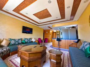 a living room with a couch and a table at Lux'Or Scandinavian-style, pool & play area in Oued Laou