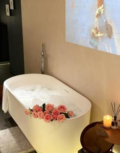Una bañera blanca con flores en el medio. en Jianye Yisu · Private Hot Spring · Aether Designer Retreat (Datong Ancient City Huayan Temple), en Datong