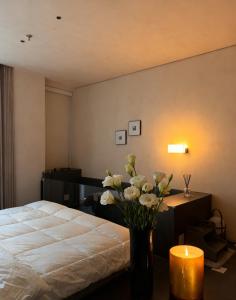 Un dormitorio con una cama y una mesa con un jarrón de flores. en Jianye Yisu · Private Hot Spring · Aether Designer Retreat (Datong Ancient City Huayan Temple), en Datong