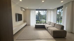 テガラランにあるPrana Ubudのソファとテレビのあるリビングルーム