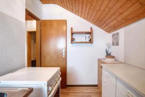 eine Küche mit weißen Arbeitsplatten und einer Holzdecke in der Unterkunft Haus Thomann in Höchenschwand + 32 Fotos