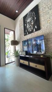 a living room with a large flat screen tv on a wall at Pranajaya paradise in Tejakula