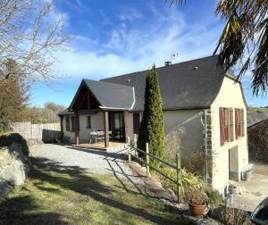 een wit huis met een zwart dak bij Marty in Rébénacq