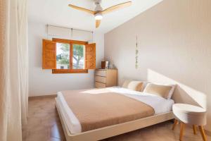a bedroom with a bed with a ceiling fan at Es Mollet de Barcares in Alcudia +74 photos