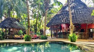 a resort with a swimming pool in front of a house at Kaya Kwetu in Msambweni