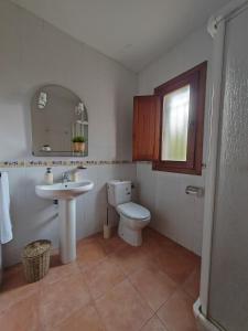 ein Badezimmer mit Toilette, Waschbecken und Spiegel in der Unterkunft El Moral Centro de Turismo Rural in Valdecañas
