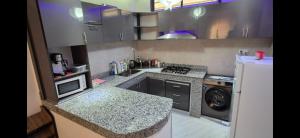 a small kitchen with a stove and a refrigerator at Thiam APPART in Nouakchott